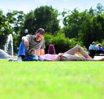 Kurpark Sommer - Paar entspannt auf Wiese