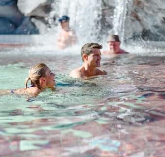 Thermenspaß - Paar schwimmt in Salzwasser-Felsenlagune