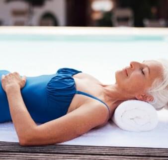 Wellness - Frau entspannt neben dem Becken