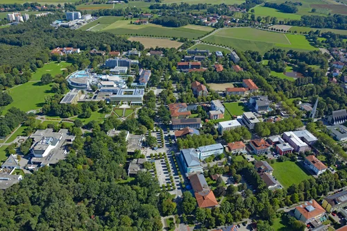 Luftaufnahme einer Stadt Luftaufnahme einer Stadt mit Wohngebäuden, Parks und einer Gebäudevielfalt mit grünen Flächen im Vordergrund.